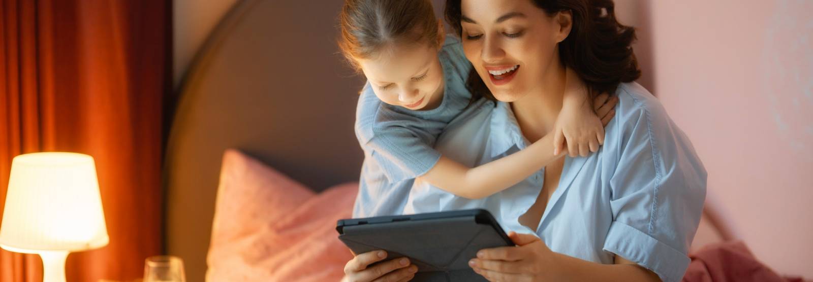 A mother and young daughter smiling together at home